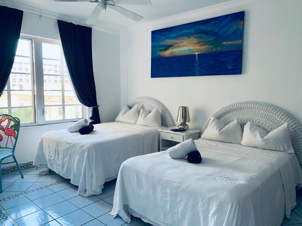 a bedroom with two beds and a window at Beachfront Ocean Dr white sand paradise SoBe 311 in Miami Beach
