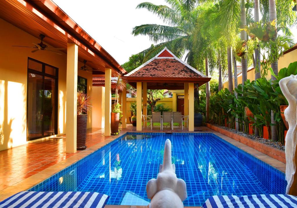 a person giving a thumbs up next to a swimming pool at 4 Bed Villa Private Pool and BBQ Jomtien Beach in Jomtien Beach