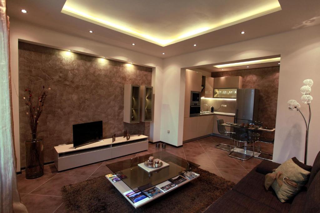 ein Wohnzimmer mit einem Sofa und einem Tisch sowie eine Küche in der Unterkunft Brown Cottage Apartment in Sofia