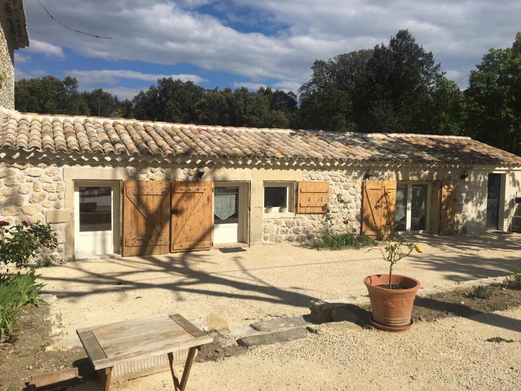 un vieux bâtiment en pierre avec un banc devant lui dans l'établissement gite le cabanon, à Réauville