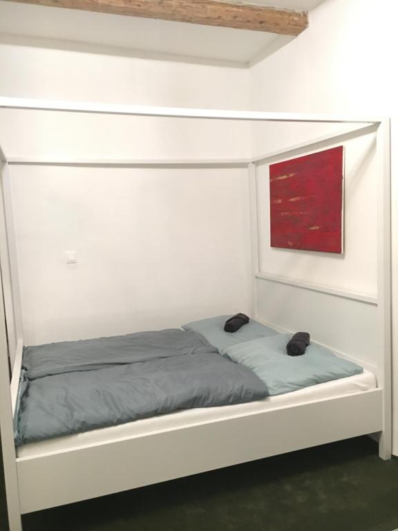 a bed in a white room with a red painting at City Center AP 2 in Košice