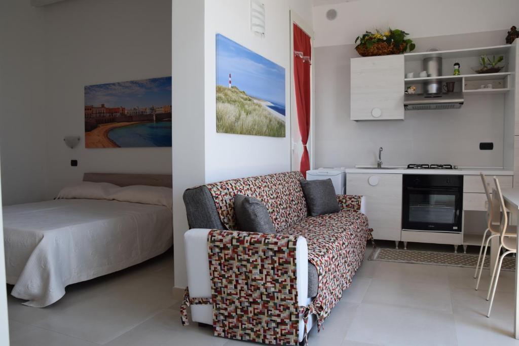 un soggiorno con divano e letto e una cucina di Appartamento Flora a Gallipoli