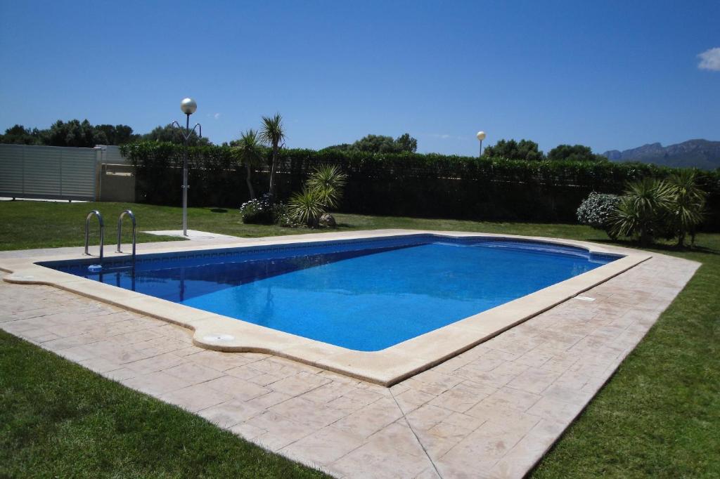 a swimming pool in a yard with a grassy yard at MEDDAYS CHALET EL SALVADOR 8 in Miami Platja