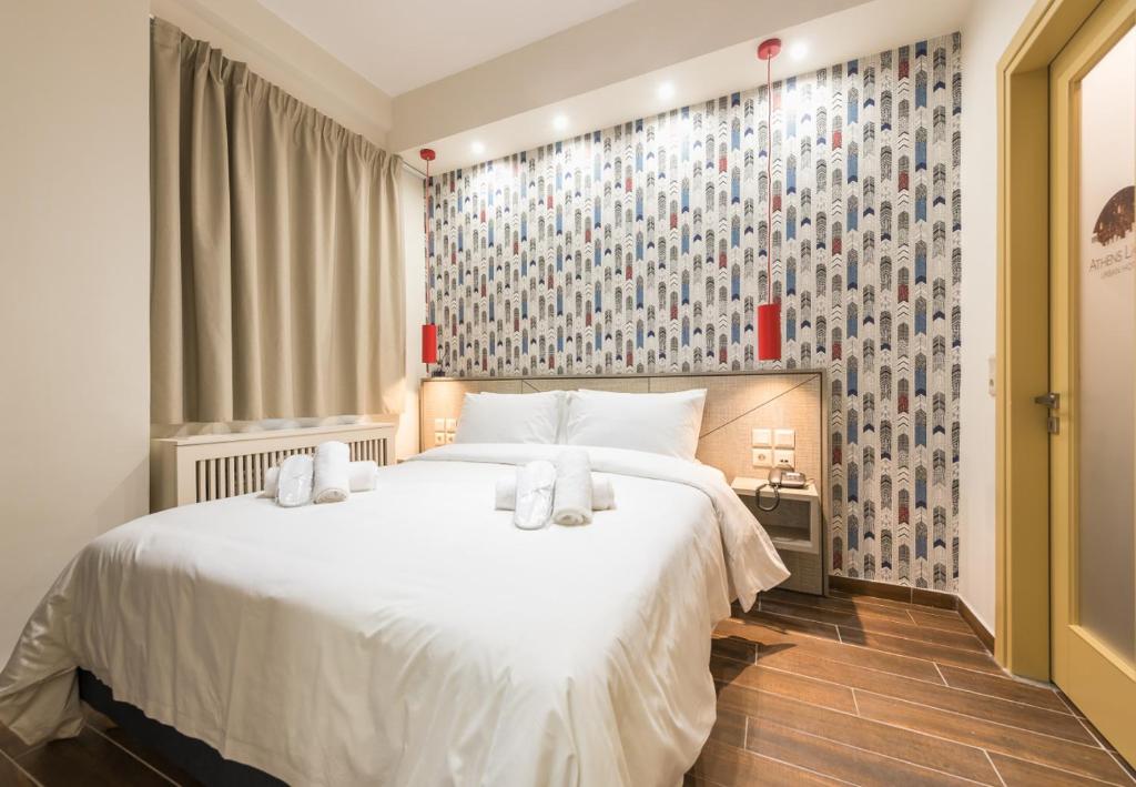 ein Schlafzimmer mit einem großen weißen Bett mit Handtüchern darauf in der Unterkunft Athens Lights in Athen