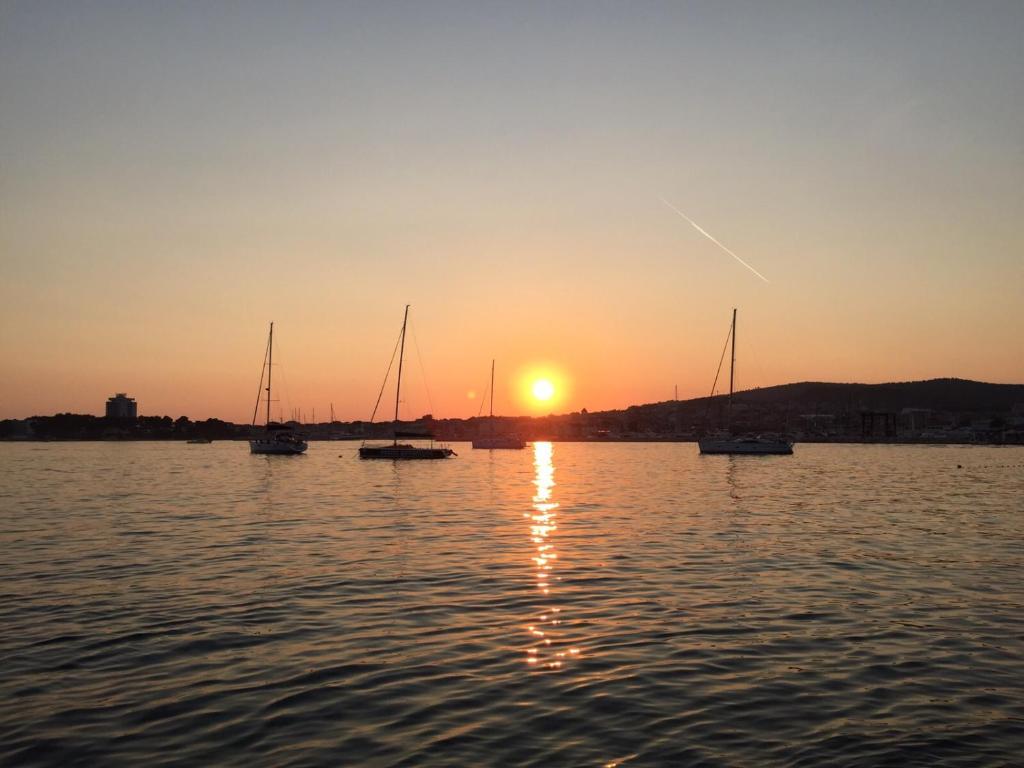 un groupe de bateaux dans l'eau au coucher du soleil dans l'établissement Villa Chiara, à Vodice