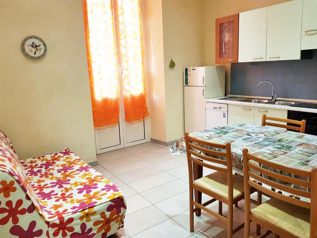 a kitchen with a table and chairs and a kitchen with a counter at Casa Luciana in Savona