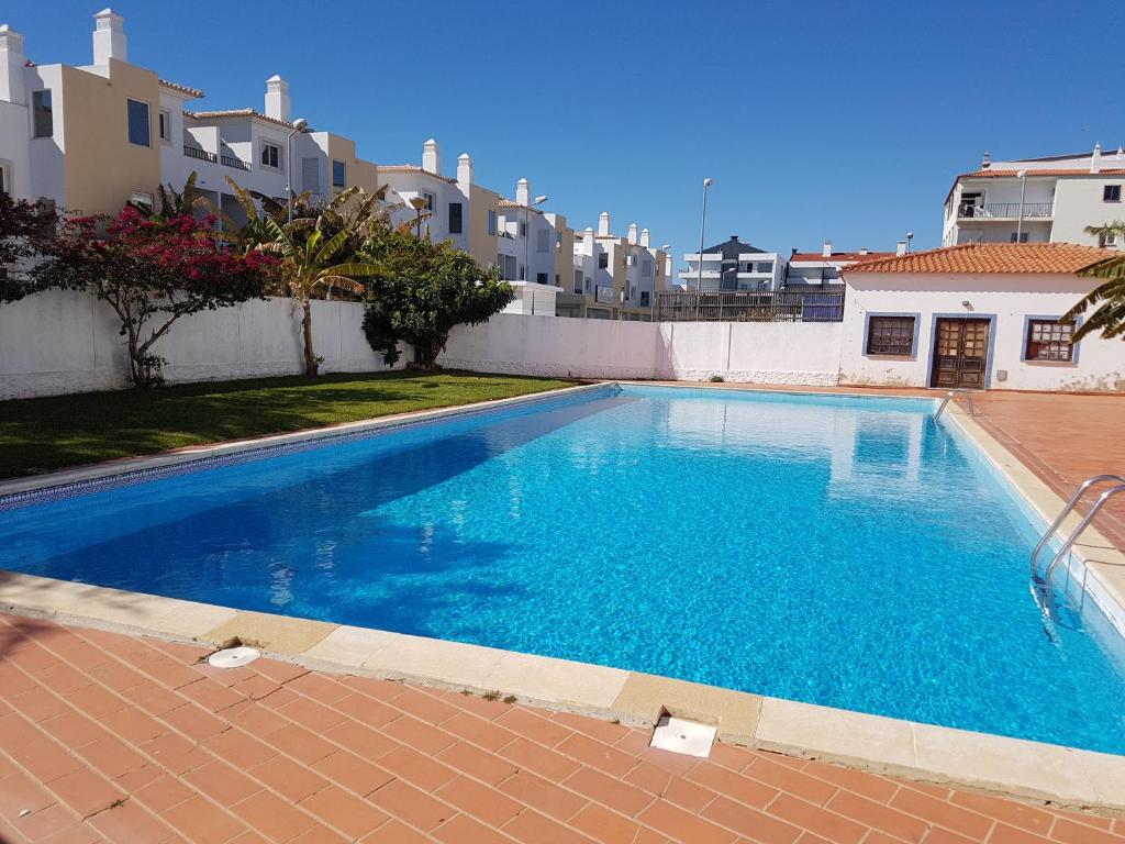een groot blauw zwembad met gebouwen op de achtergrond bij Apartment Santa Eulalia Albufeira in Albufeira