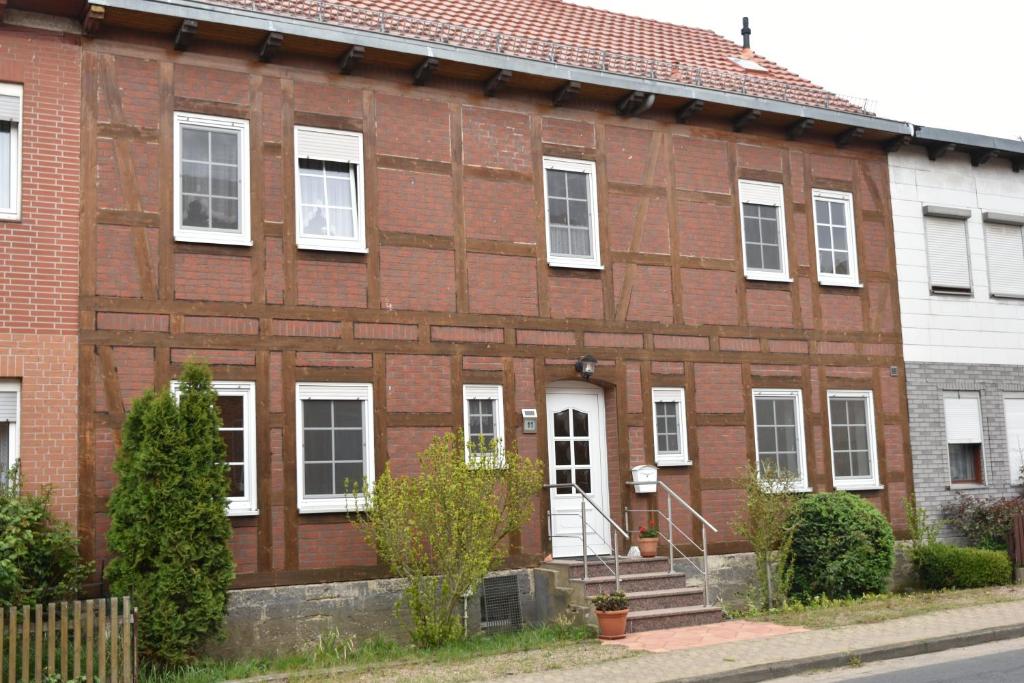 una casa in mattoni rossi con finestre e scale bianche di Ferienwohnung an der alten Schunter a Süpplingenburg