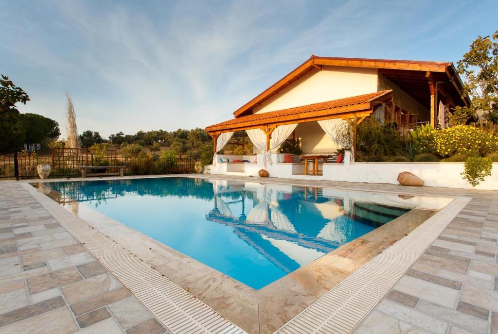 Ionia Guest House في أيدين: حمام سباحة مع شرفة بجوار منزل