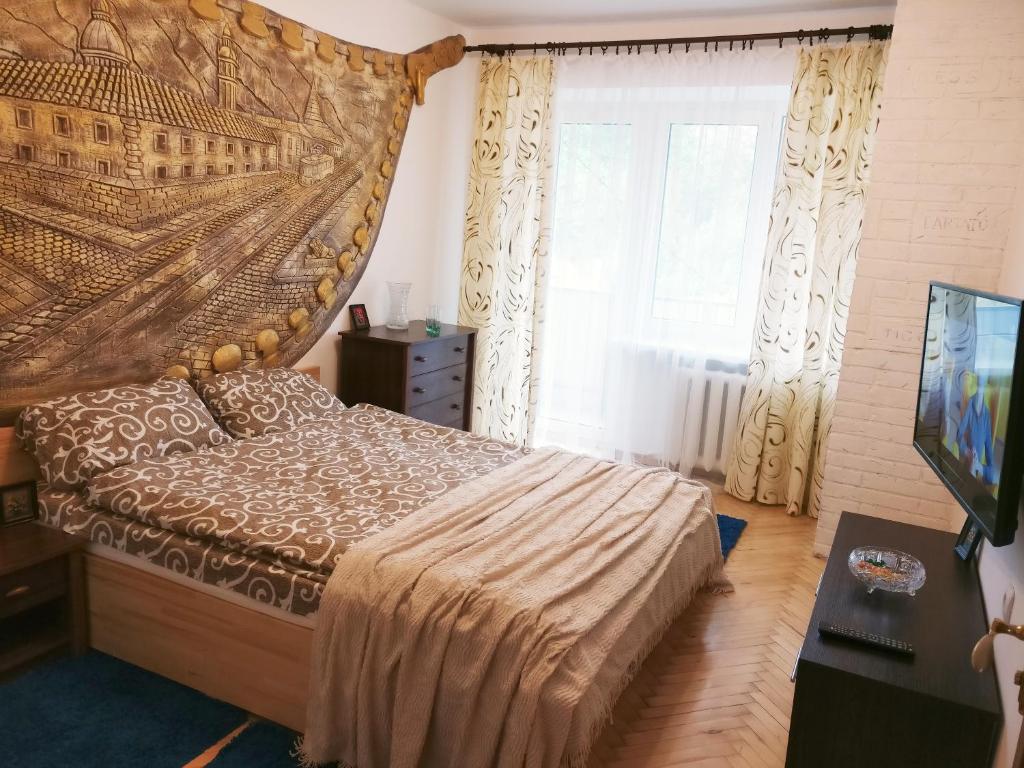 um quarto com uma cama, uma televisão e uma janela em Very nice Apartment in L'viv em Lviv