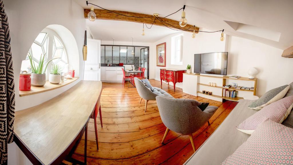 kuchnia i salon z długim stołem i krzesłami w obiekcie L'appartement de Margot w mieście Bordeaux