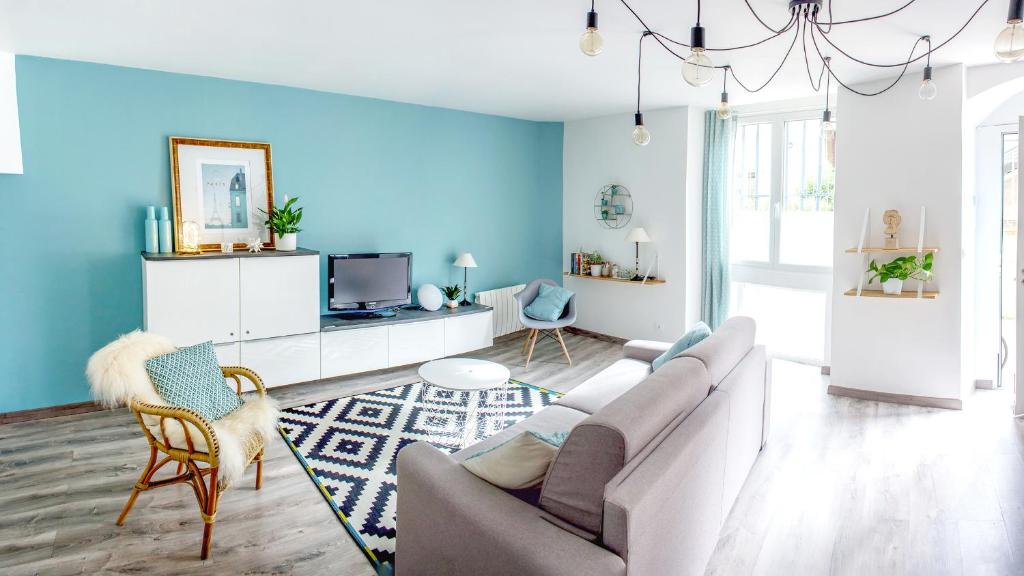 sala de estar con sofá y pared azul en La Maison de Valentine en Burdeos