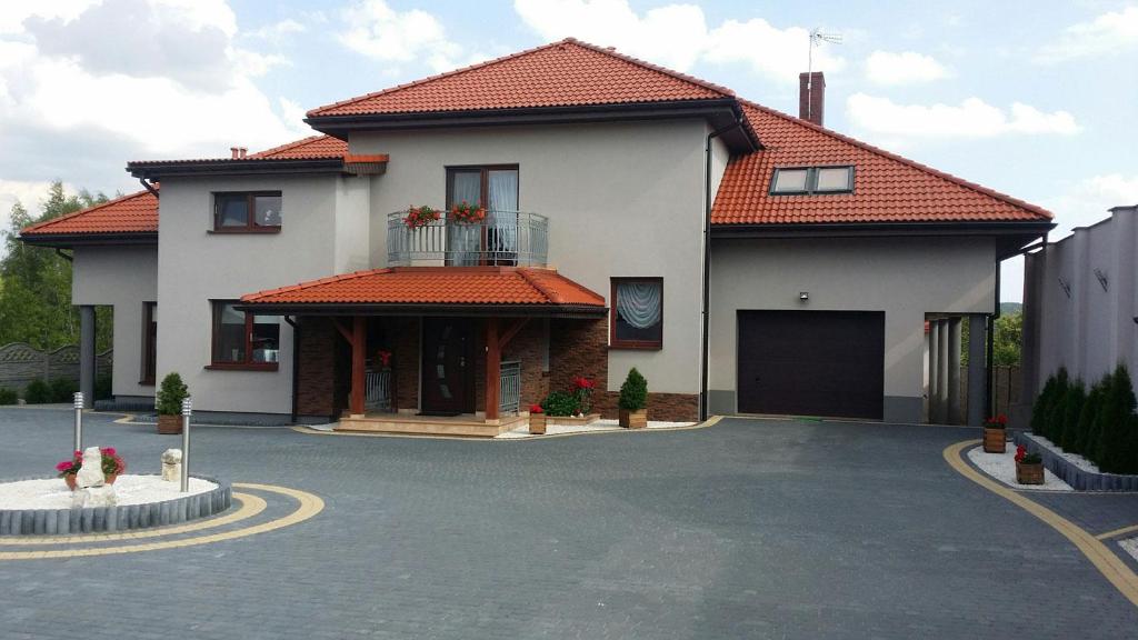 una casa con un estacionamiento delante de ella en Ostoja Jurajska en Hucisko