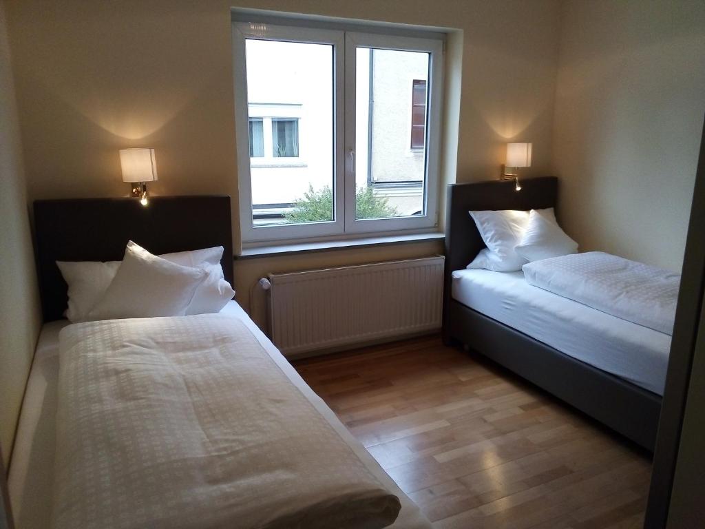 two beds in a room with a window at Boardinghouse Stadtmauer in Schwandorf in Bayern