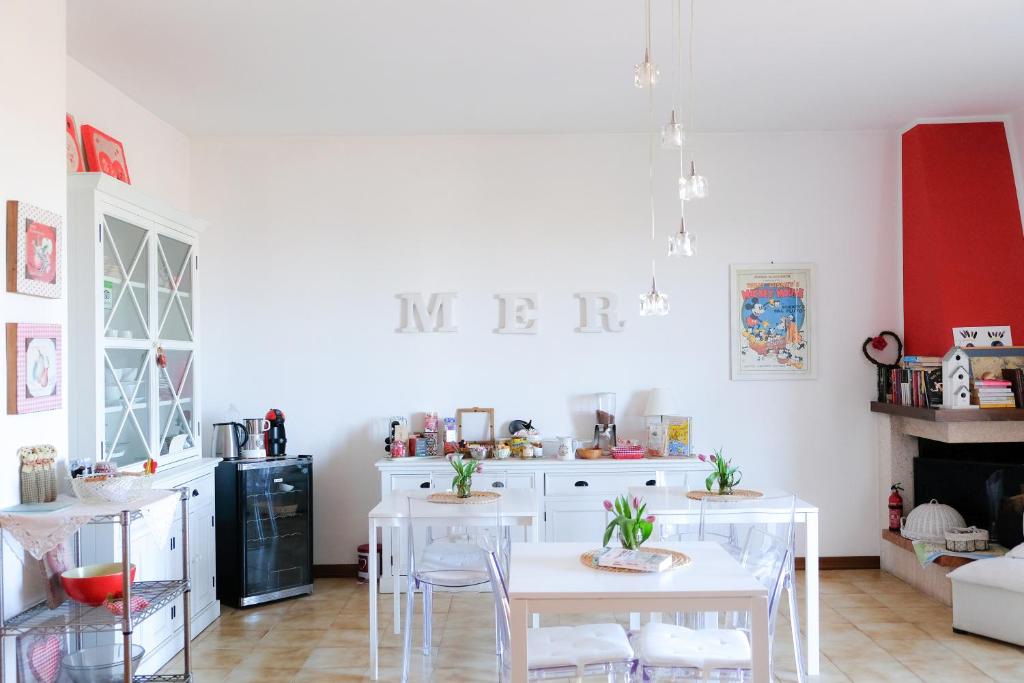 kuchnia z białymi stołami i krzesłami w pokoju w obiekcie ilmareinmezzo w mieście Porto Recanati