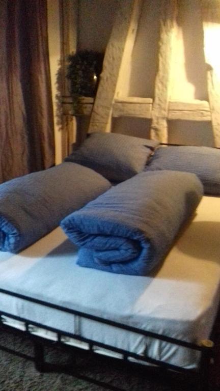 a row of beds with blue pillows on them at Rheintal-Zimmer in Altstätten