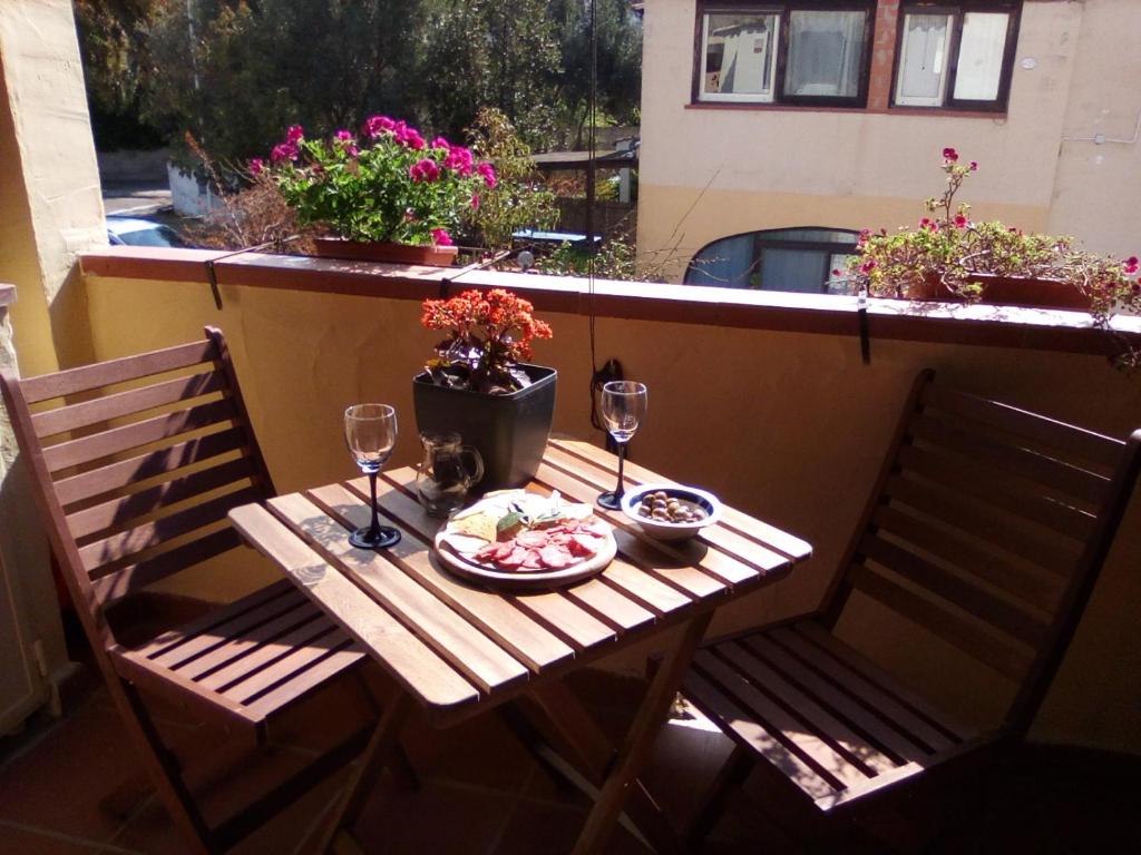 une table avec une assiette de nourriture et deux verres de vin dans l'établissement Casa Vacanze Paola 2, à Santa Luria