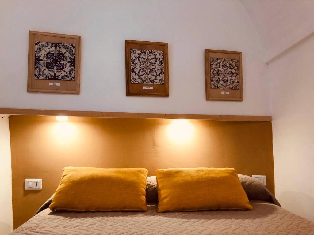 a bedroom with a bed with three pictures on the wall at A casa dei Sasso, Laetitia Suite in Positano