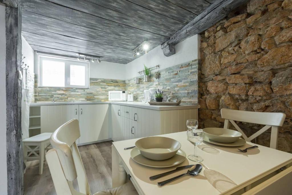 une cuisine avec une table et des chaises et un mur en pierre dans l'établissement Cannes croisette, à Cannes