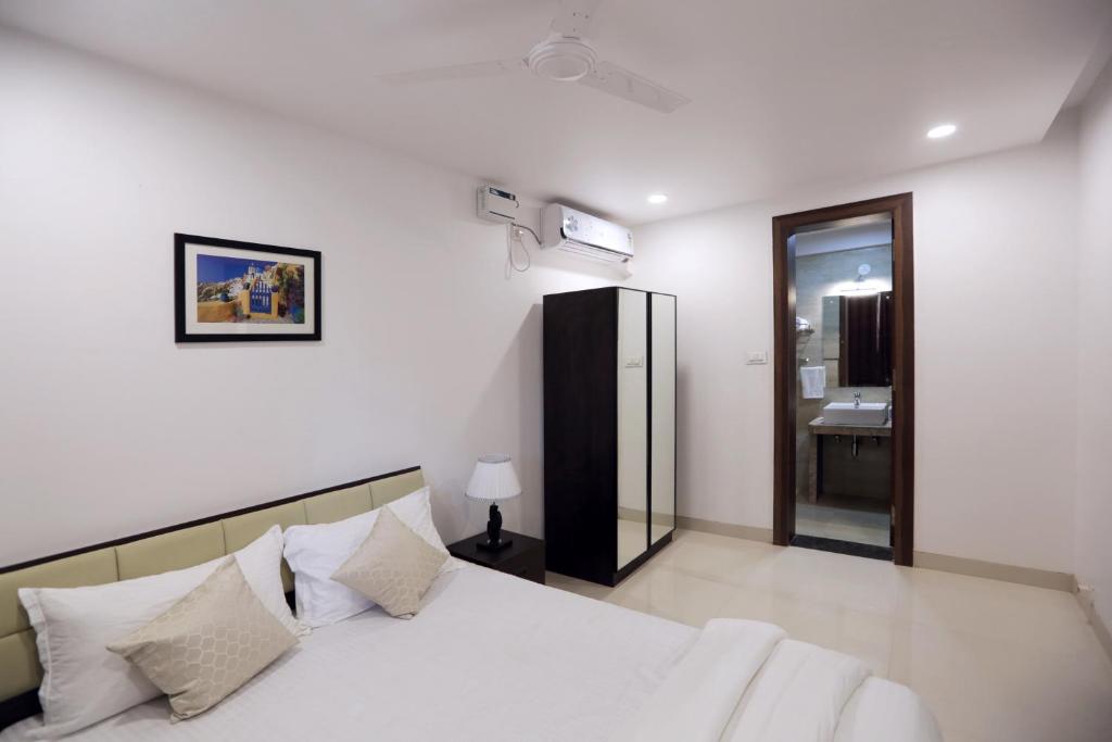 1 dormitorio con cama blanca y lavamanos en Goa Junction by Daystar Ventures, en Anjuna