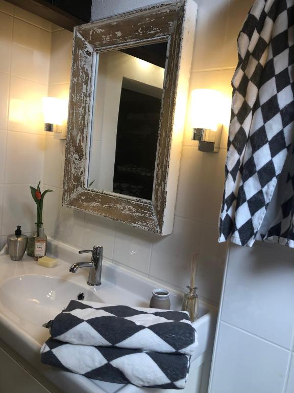 a bathroom sink with a mirror and a towel on it at Atelier Kurt in Hinterbrühl