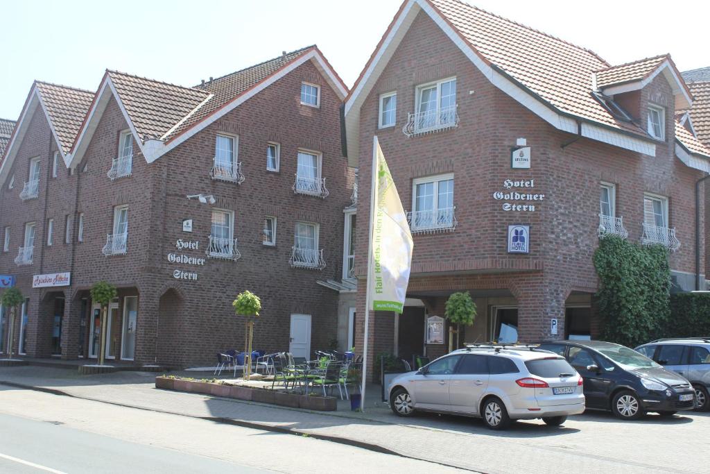 um edifício com carros estacionados em frente em Hotel Goldener Stern em Ascheberg