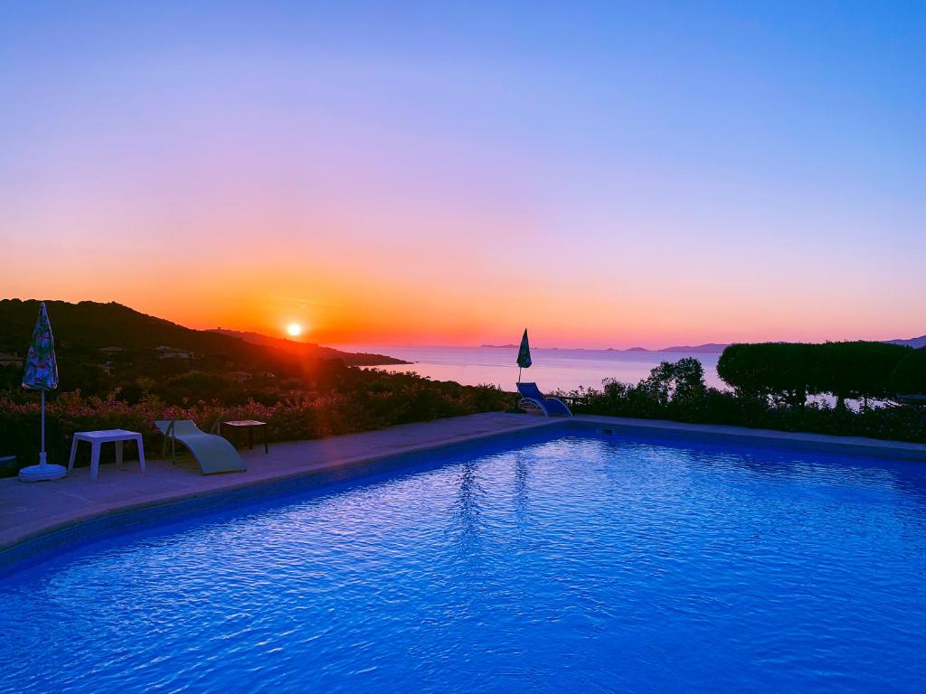 une grande piscine avec un coucher de soleil en arrière-plan dans l'établissement Hotel Celine, à Coti-Chiavari