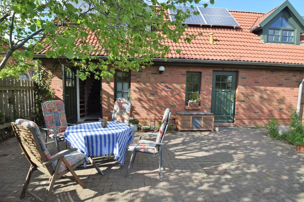 um pátio com uma mesa e cadeiras em frente a uma casa em Ferienwohnungen Meyer em Bollewick