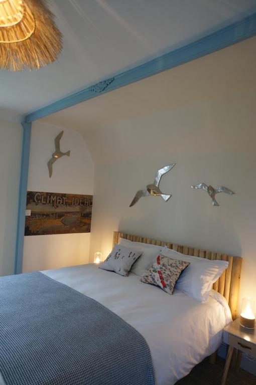 a bedroom with a bed with two birds on the wall at L'écrin de l'Océan, 80 mètres de la mer. in Le Pouliguen