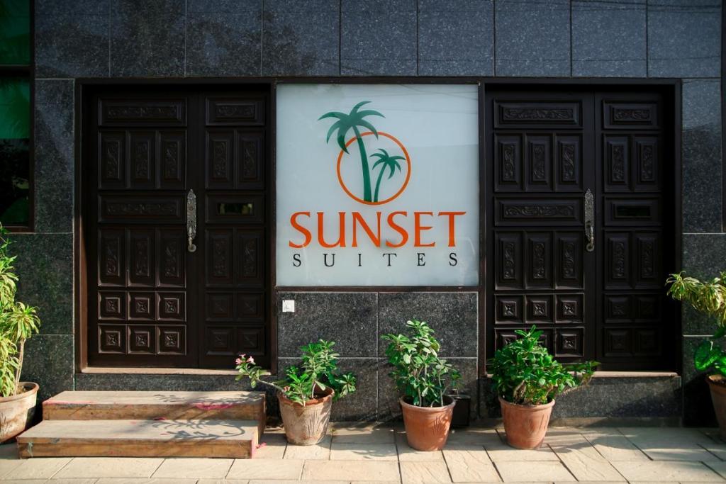 a restaurant with two doors and potted plants in front at Sunset Suites in Karachi