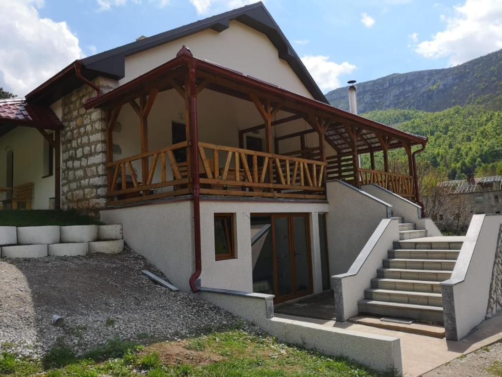 a house with a balcony and stairs in front of it at Apartmani Gmitrovic in Rtanj