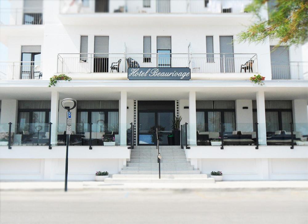 a white building with a sign on the front of it at Hotel Beaurivage in Senigallia