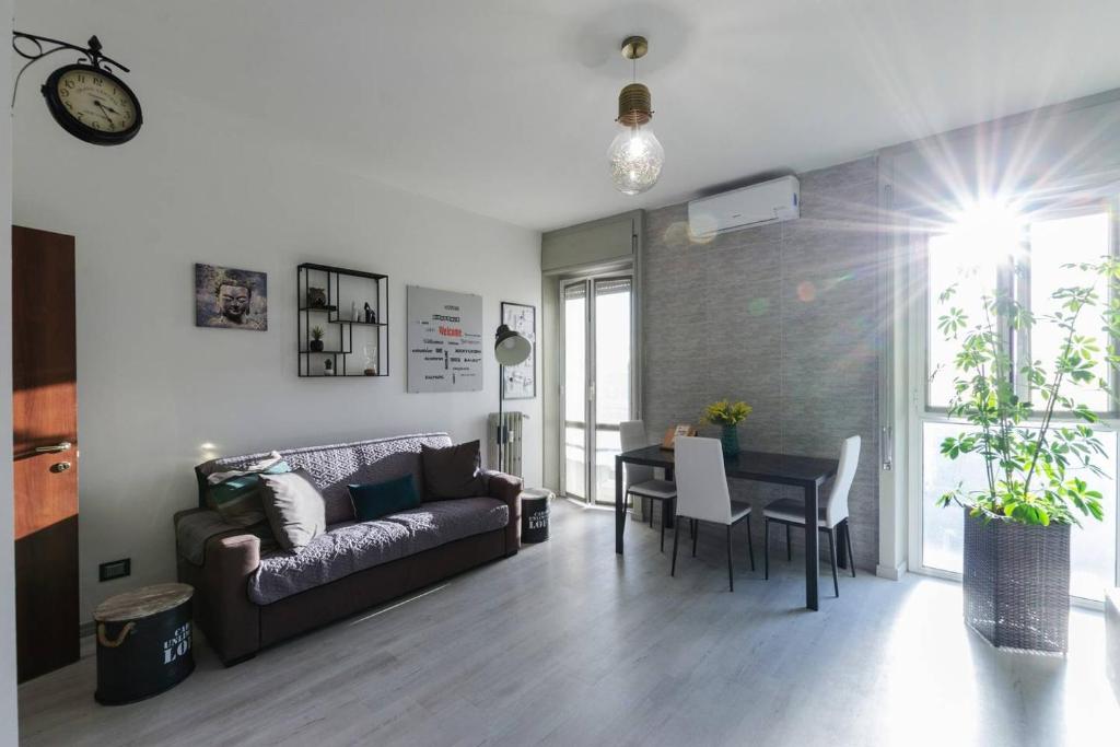 uma sala de estar com um sofá e uma mesa em Appartamento moderno San Siro em Milão