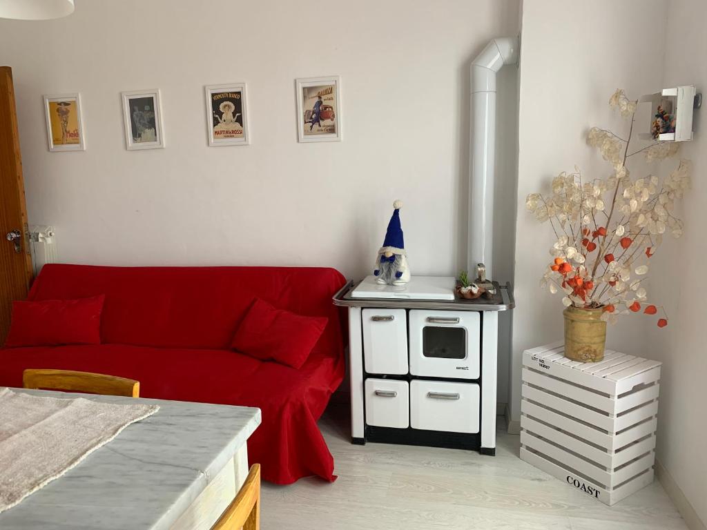 a living room with a red couch and a stove at Cozy Home in Monte Amiata in Abbadia San Salvatore