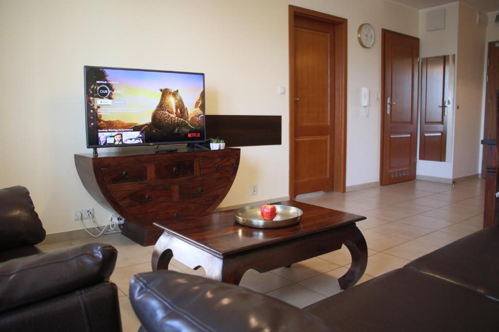 a living room with a tv and a coffee table at Apartament Kolonialny Olympic Park in Kołobrzeg