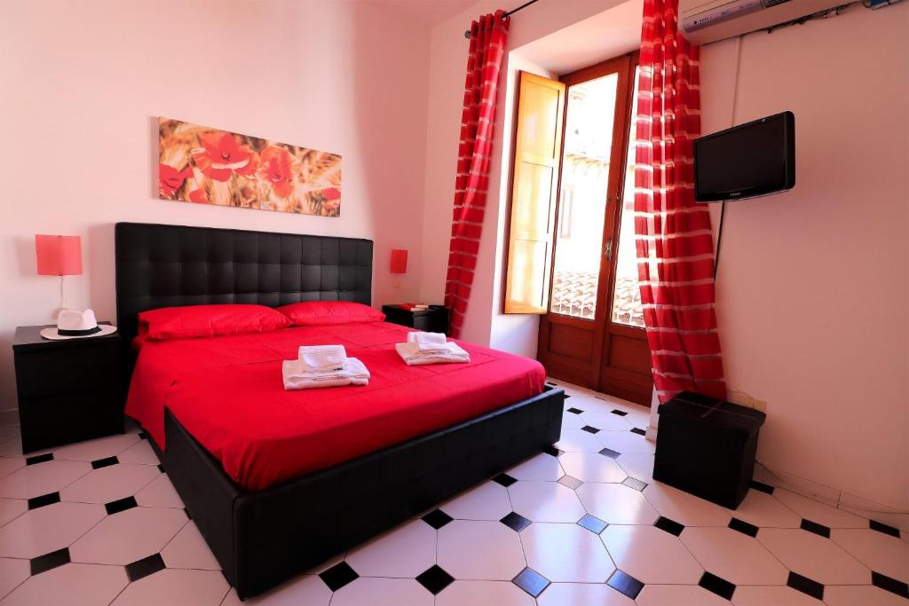 una camera da letto con letto rosso con lenzuola rosse e finestra di Estate4home - SORRENTO HEARTS a Sorrento