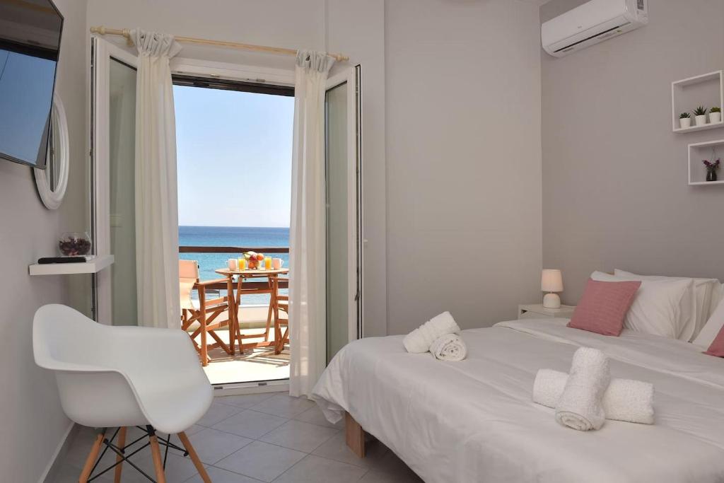 a bedroom with a bed and a view of the ocean at Aegean View Studio #2 in Azolimnos Syros