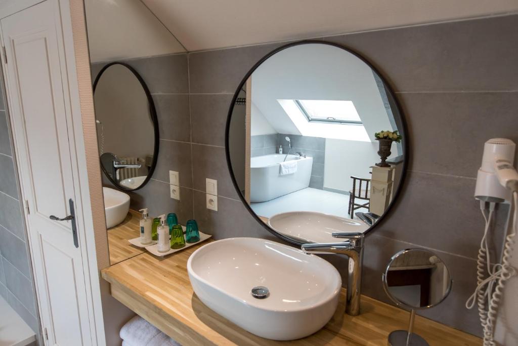 a bathroom with two sinks and a large mirror at Domaine Utah Beach - Le Grand Hard in Sainte-Marie-du-Mont