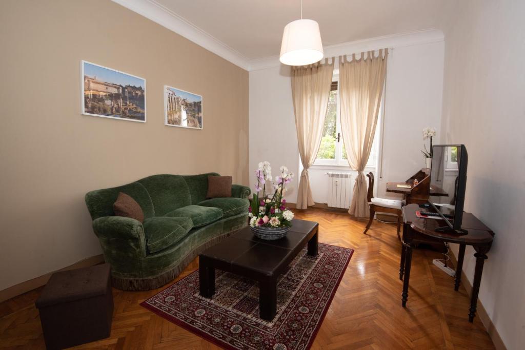salon z zieloną kanapą i stołem w obiekcie Appartamento Luminoso con vista su Villa Ada w Rzymie
