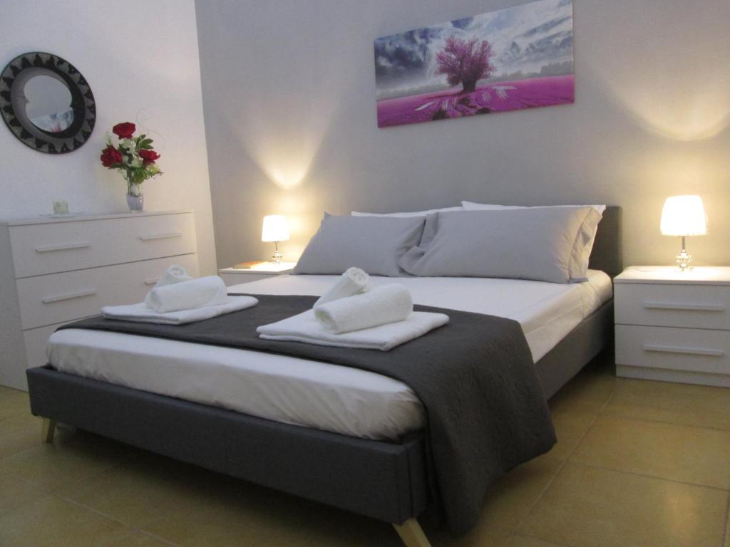 1 dormitorio con 1 cama con 2 toallas en Maison Gigante, en San Donato di Lecce