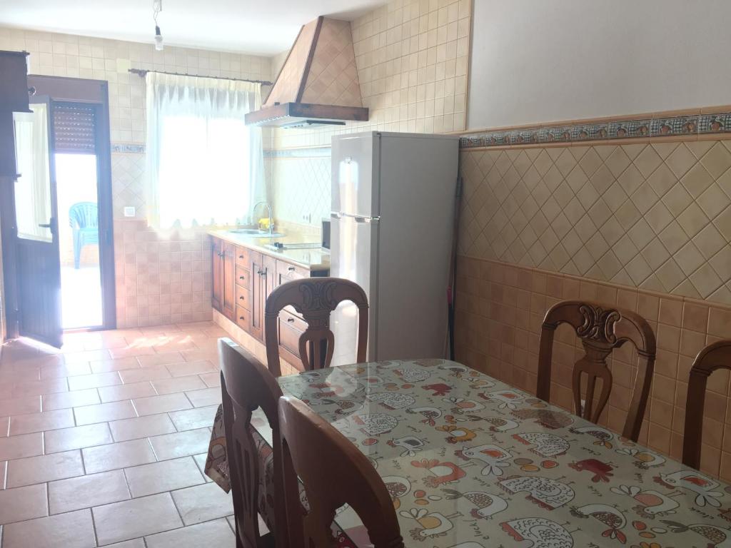 a kitchen with a table and chairs and a refrigerator at El Corral de Dolores in El Bosque