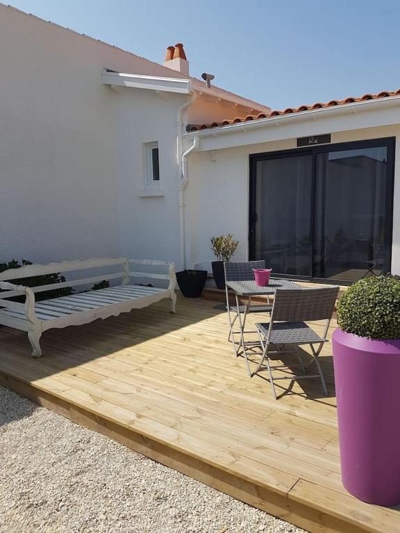 a patio with a bench and a table and chairs at Appartement Ré (4 personnes) in Châtelaillon-Plage