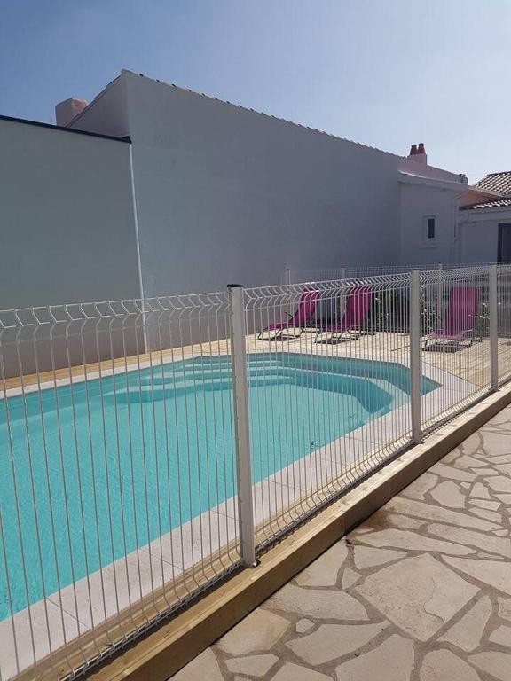 une clôture autour d'une piscine dans une maison dans l'établissement Appartement Ré 2 personnes, à Châtelaillon-Plage