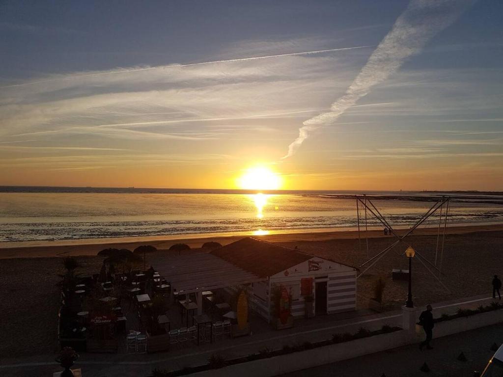 a sunset on the beach with the sun setting at Appartement Ré (4 personnes) in Châtelaillon-Plage