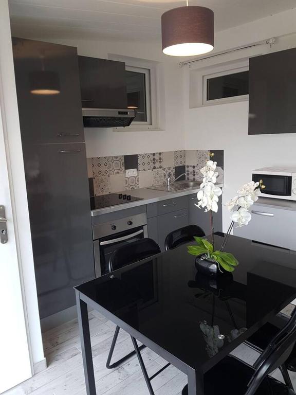 a kitchen with a black table with a black dining room at Appartement Ré (4 personnes) in Châtelaillon-Plage