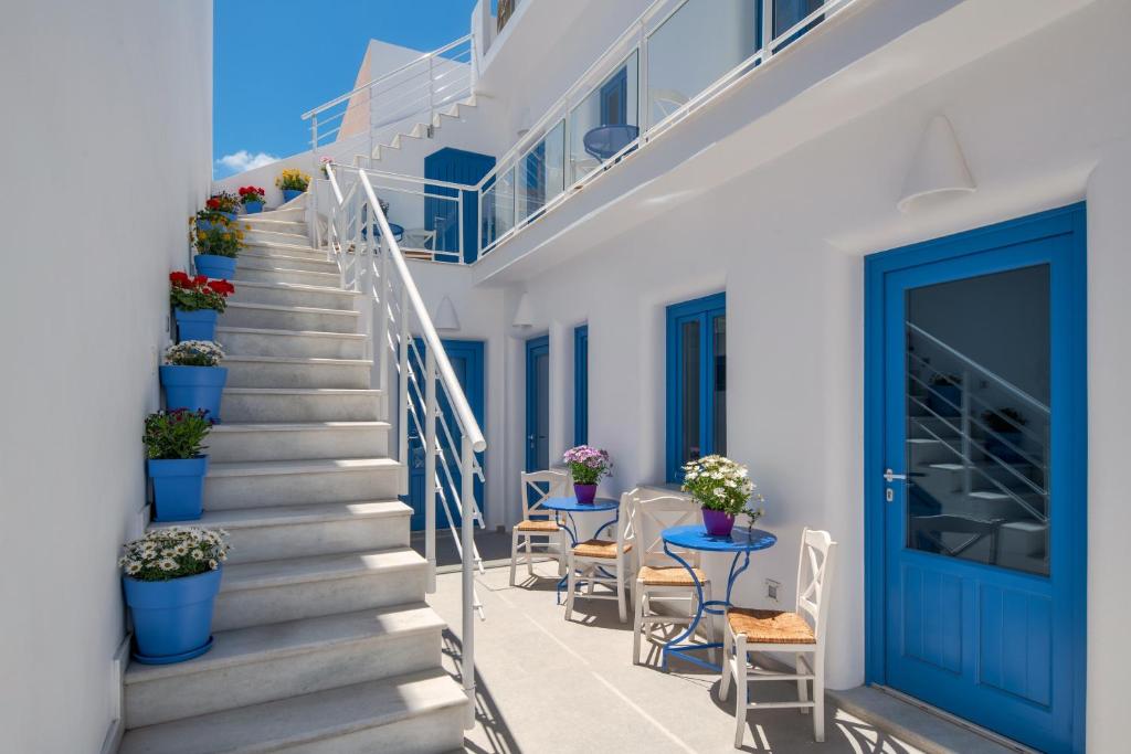 a staircase in a house with blue doors and plants at City Break in Fira