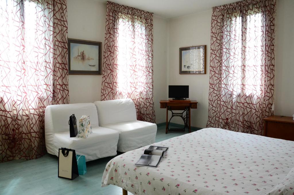 リード・ディ・ヴェネツィアにあるVillino Lambertoのベッドルーム(白いベッド1台、白い椅子付)