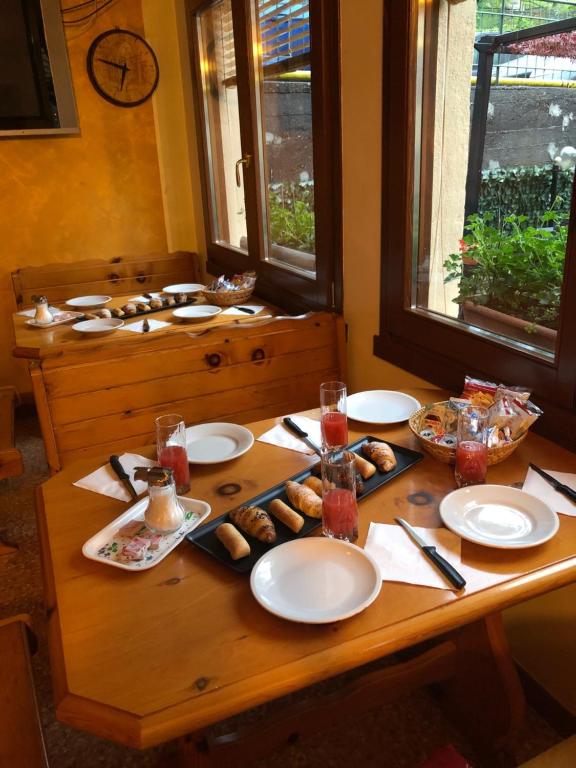 a wooden table with plates of food on it at Ostello Trentapassi in Zone