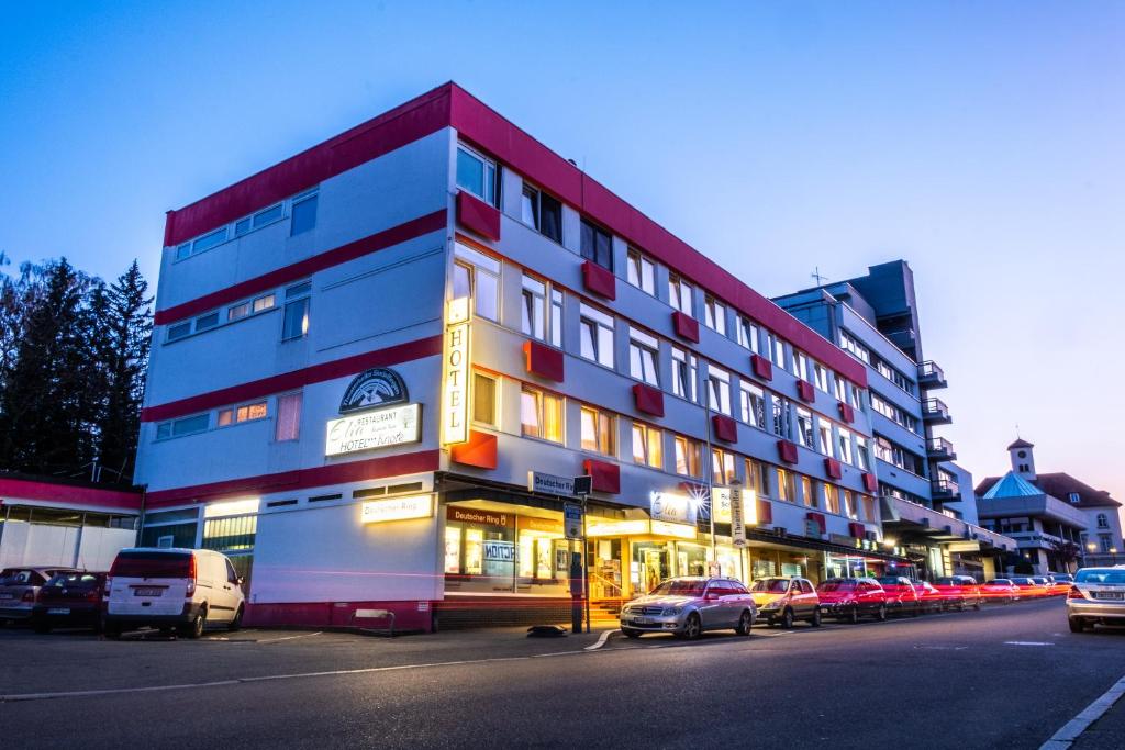 ein Gebäude mit Autos auf einem Parkplatz in der Unterkunft Hotel & Restaurant Knote in Sindelfingen