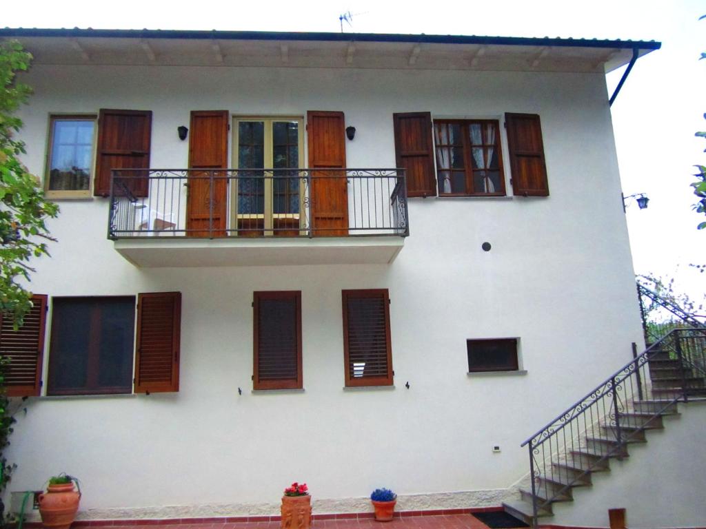 a white building with wooden windows and a staircase at Appartamento Panoramico in Montepulciano